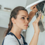 female worker repairing air conditioner