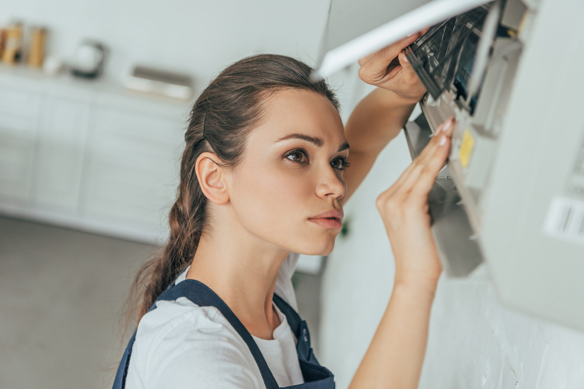 female worker repairing air conditioner