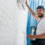 smiling workman looking at camera while repairing