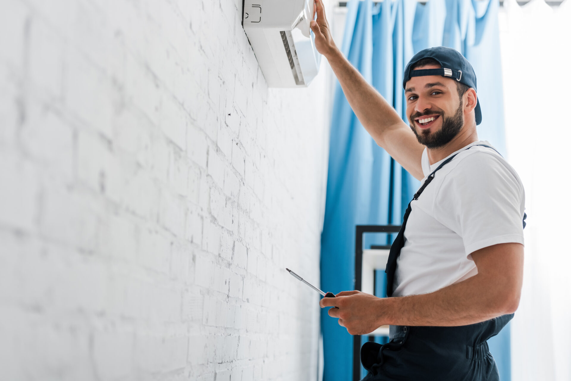 smiling workman looking at camera while repairing