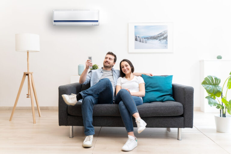 Happy couple on the sofa cool down using air conditioner at home talking about hvac installation