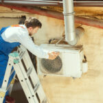 hvac technician working on a capacitor part for condensing unit